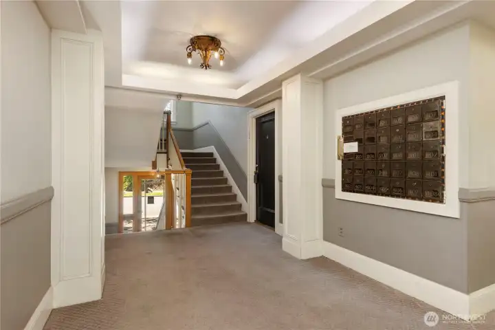 Here is lobby entrance with steps leading to 2nd floor end unit 202 and inside mail boxes for easy access.  Stairs leading down to main floor entrance, laundry room and storage entrance
