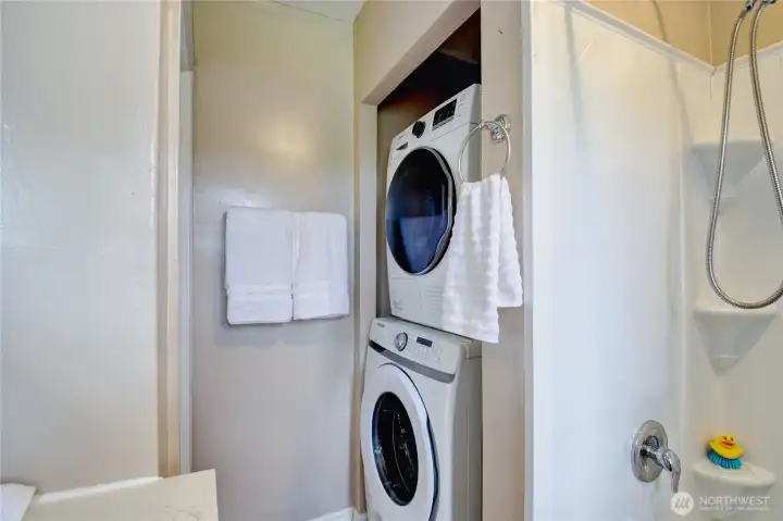 Stack washer/dryer stay with home, located in main bathroom.