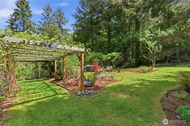 Stroll the side yard and enjoy this fruit bearing grape arbor. Stroll the side yard and enjoy this fruit bearing grape arbor.