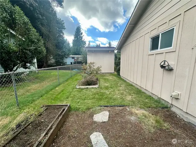 South side yard with garden space and mature blueberry bushes!