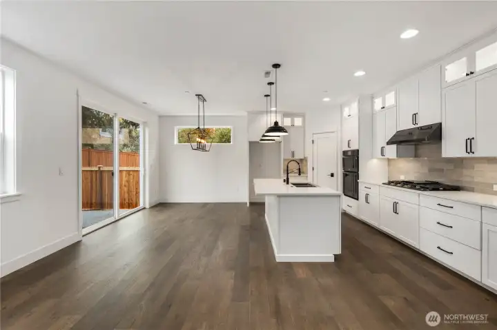 Kitchen & Dining Overview:  This combined kitchen and dining area is framed by expansive windows and sliding glass doors that bring in soft natural light and connect the interior to the private backyard. The generous layout allows for a full-size dining table while maintaining clear sightlines to the kitchen and great room. Nestled within Bothell’s Canyon Park area, the space offers a convenient balance between neighborhood living, commuter access, and the outdoor recreation that defines the PNW lifestyle. Its clean lines, warm flooring, and contemporary lighting create a welcoming setting for gatherings of all sizes.    These photos are from Lot 5 at Gooden Hollow, which is the same floorplan, but a different home than listed here. However, other homes in the community will have changes, so all photos, renderings, site maps, and floorplans are for visualization purposes only. Plans, colors, building orientation, finishes, home outlook, and other details can and WILL vary.