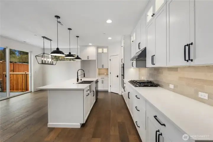 Kitchen Workspace:  This well-appointed kitchen features full-height shaker cabinetry, sleek quartz counters, and a modern tile backsplash that adds texture and warmth. The layout maximizes storage and prep space, keeping everything within easy reach while maintaining a streamlined aesthetic. As part of Bothell’s Canyon Park community, the home benefits from nearby parks, dining, and transit options that support a balanced Pacific Northwest lifestyle. Thoughtful lighting, upgraded appliances, and polished finishes elevate the space for both everyday cooking and more ambitious culinary projects.    These photos are from Lot 5 at Gooden Hollow, the home listed here. However, other homes in the community will have changes, so all photos, renderings, site maps, and floorplans are for visualization purposes only. Plans, colors, building orientation, finishes, home outlook, and other details can and WILL vary.