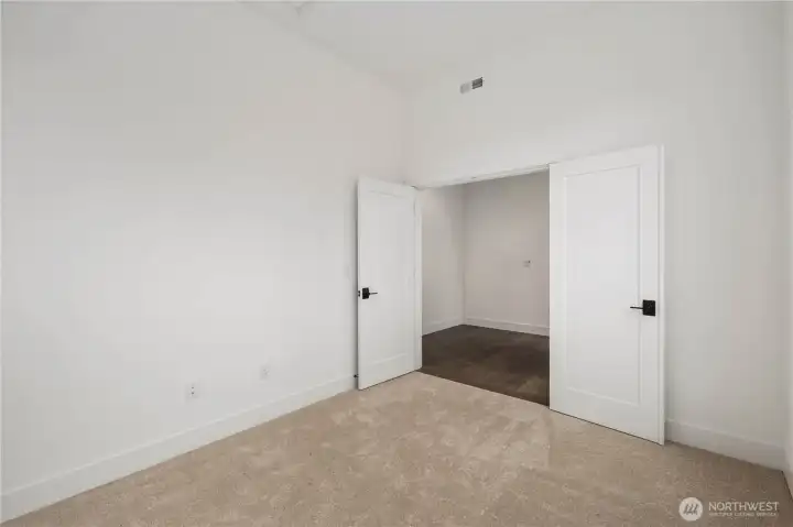 Den / Home Office – Interior View:  The den’s double doors open to a quiet, well-proportioned room with high ceilings and soft carpeting, creating a comfortable environment for working or retreating from the activity of the main living areas. Its separation from the great room enhances privacy while maintaining easy access to the rest of the first floor. Positioned within the Canyon Park community of Bothell, this additional main-level space offers proximity to local amenities, parks, and transit routes that support work-from-home living. Its simplicity and scale make it an adaptable extension of the home’s overall functionality.    These photos are from Lot 5 at Gooden Hollow, which is the same floorplan, but a different home than listed here. However, other homes in the community will have changes, so all photos, renderings, site maps, and floorplans are for visualization purposes only. Plans, colors, building orientation, finishes, home outlook, and other details can and WILL vary.