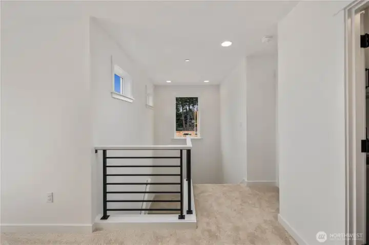 Landing / Upper Hallway:  This open upper landing is bright and inviting, framed by elevated windows that pull in natural light while maintaining privacy. The wide hallway makes the second floor feel connected and easy to navigate, creating a smooth transition between the bedrooms, loft, and primary suite. Its position in Bothell’s Canyon Park area places you minutes from local trails, shops, and the Eastside commuting corridors. Clean modern railings and soft, neutral finishes help the space feel calm and contemporary.    These photos are from Lot 5 at Gooden Hollow, which is the same floorplan, but a different home than listed here. However, other homes in the community will have changes, so all photos, renderings, site maps, and floorplans are for visualization purposes only. Plans, colors, building orientation, finishes, home outlook, and other details can and WILL vary.