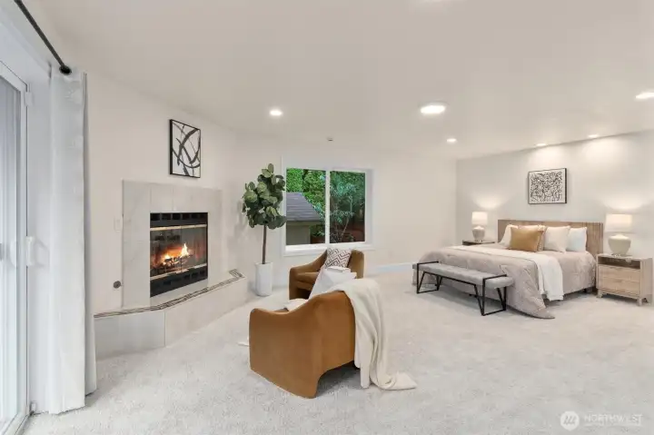 Spacious main-floor primary suite with sitting area and cozy fireplace.