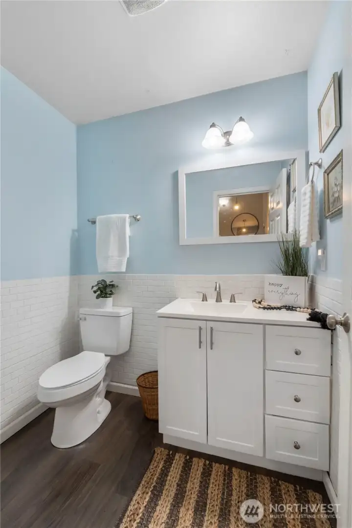 Nicely tucked away, the downstairs powder room has a subway tile surround and updated vanity with storage & upgraded countertop