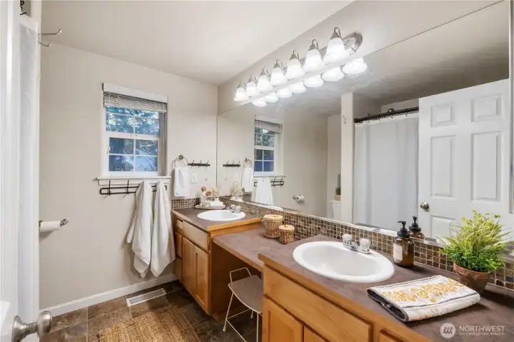 The full bath off the primary bedroom has double sinks, a vanity area and lots of storage & counter space