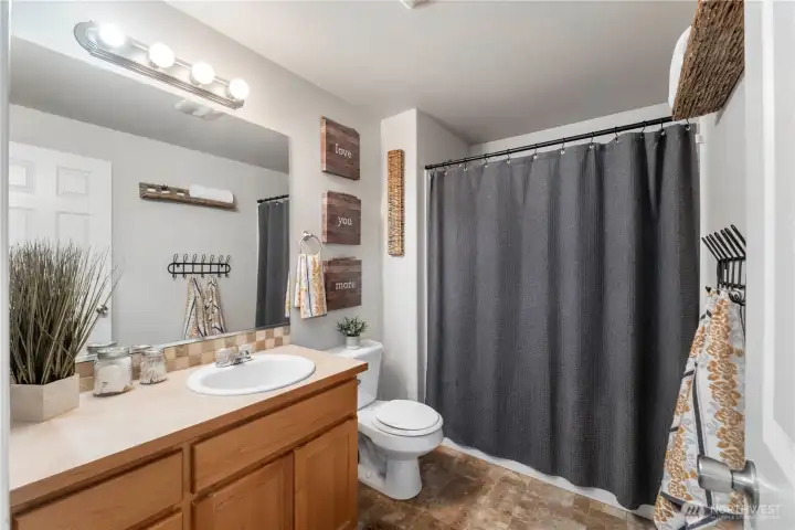 The full bath upstairs has an ample countertop & tile surround