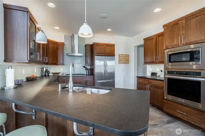 View 3 of kitchen with wood cabinets, high-end stainless steel appliances and granite countertops.