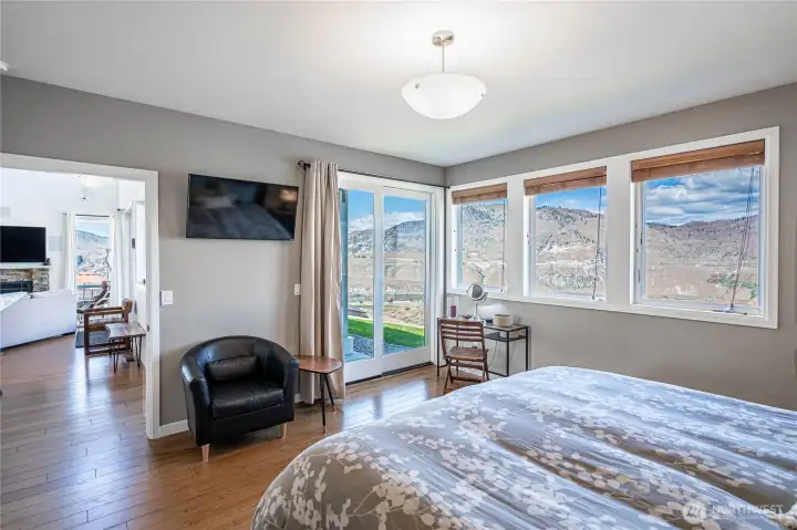 View 2 of main level Primary Bedroom with en-suite bathroom, walk in closet and French doors leading to the view deck.