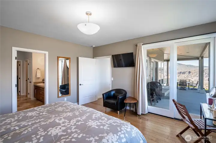 View 3 of main level Primary Bedroom with en-suite bathroom, walk in closet and French doors leading to the view deck.