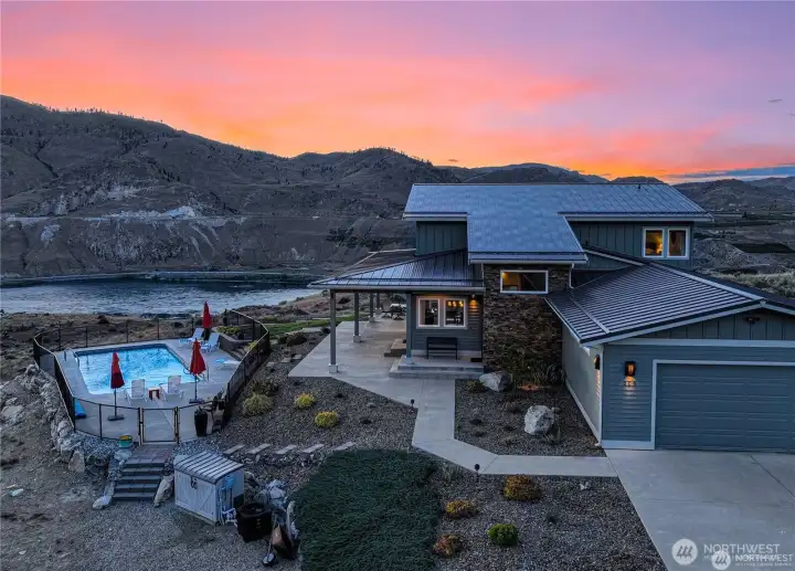 Twilight view of home and pool fronting the Columbia River.