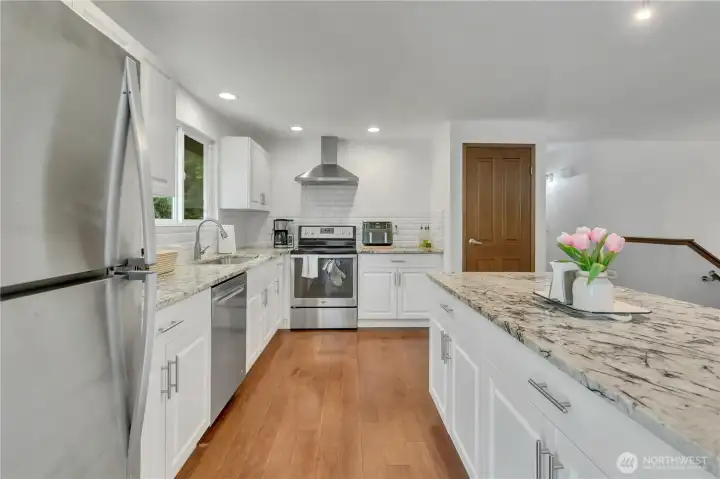 The fully remodeled kitchen shines with modern finishes, stylish cabinetry, and seamless flow into the main living and dining areas, perfect for entertaining.