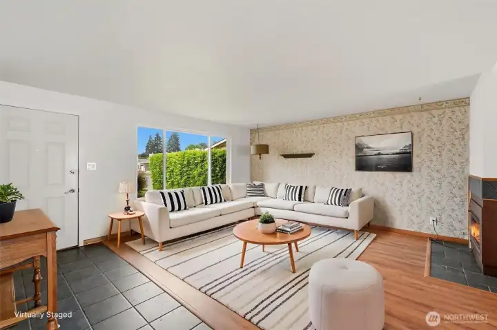 Another view of the charming living room with windows that overlook the front yard. (Shown virtually staged)