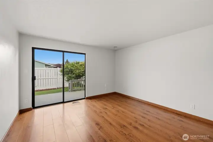 Another view of the spacious primary bedroom with a lovely sliding glass door out to a back deck.