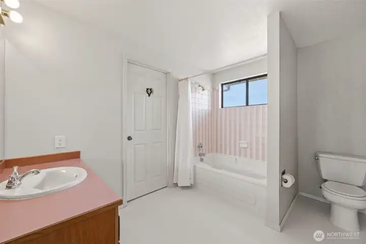 The upstairs full bathroom showing the bedroom access door.