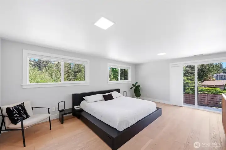 Light-filled primary bedroom with balcony overlooking the private grounds. Light-filled primary bedroom with balcony overlooking the private grounds.