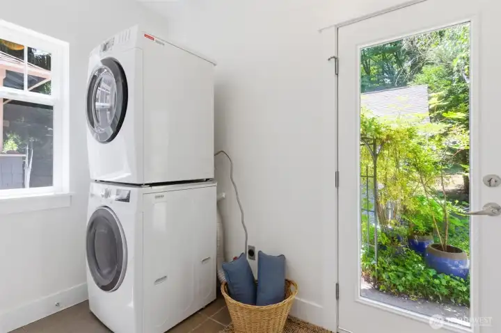 Laundry utility area/mudroom with adjacent half bathroom and access to the garden and detached garage. Laundry utility area/mudroom with adjacent half bathroom and access to the garden and detached garage.