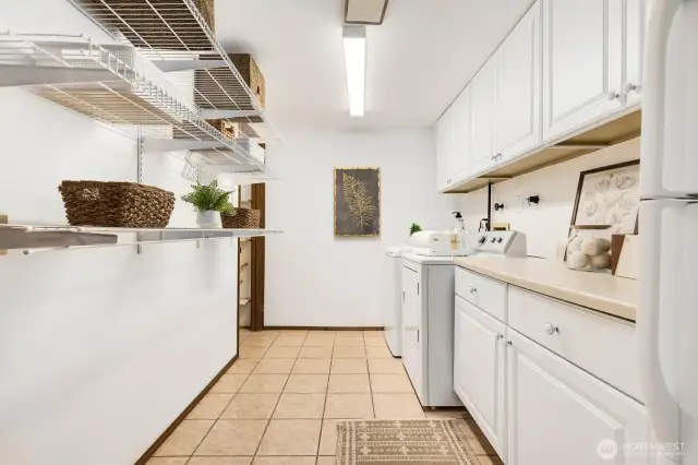 Expansive laundry room downstairs with plenty of additional storage space.  Washer, dryer, additional refrigerator all stay with the home