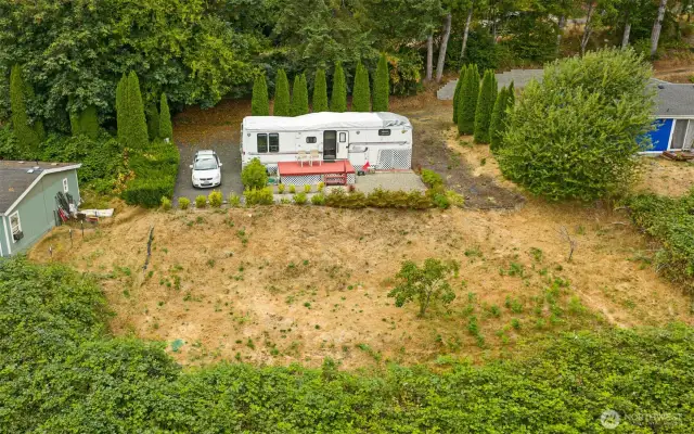 This partially sloped lot offers a broad, level area at the top, providing versatile space for future use, while the drainfield rests on the lower section.