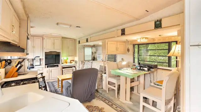 A dining area for four is perfectly positioned next to a generous window that brightens the space and offers a scenic backdrop.