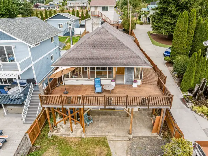 A view of the back side showing the deck, patio and yard.