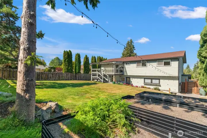 Large, fenced rear yard with garden spaces.