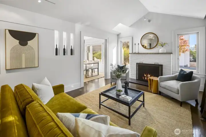 Light-filled living with vaulted ceiling and fireplace; open to dining for seamless entertaining.