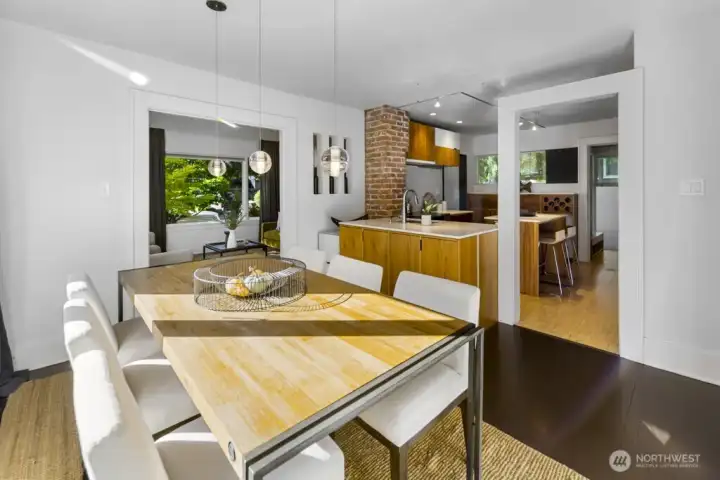 Dining flows into the kitchen—brick accent and wide pass-through make serving and conversation easy.