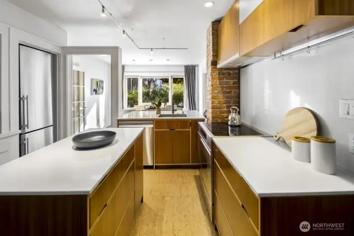 Galley layout with central island and long sightline to dining space—great for prepping and hosting.