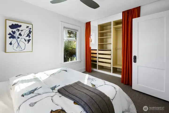 Bedroom includes an organized closet system and drapery—everything has a place.