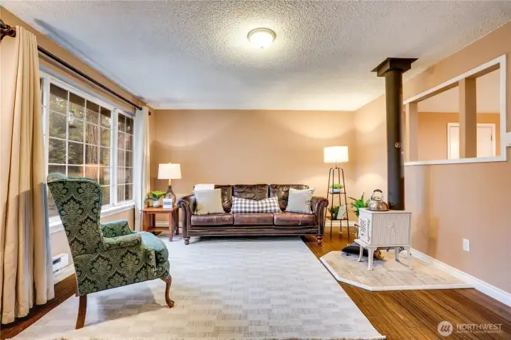 Step inside to the cozy living room, where you can curl up by the wood stove and enjoy serene views through the picture window.