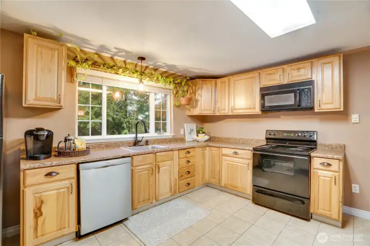 Enjoy modern convenience with a newer dishwasher, generous counter space, and cabinets galore for storage.
