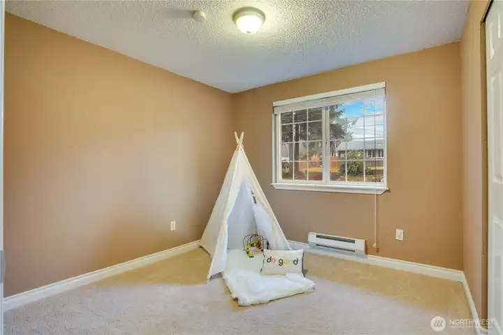 Across the hall, the second bedroom offers a bright and inviting space with large windows that welcome natural light.