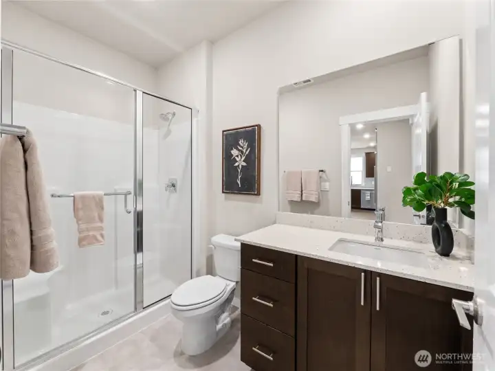 Main level bathroom with walk-in shower. Photo is representational. Actual home is under construction and finishes and paint colors may vary. See site agent for details....