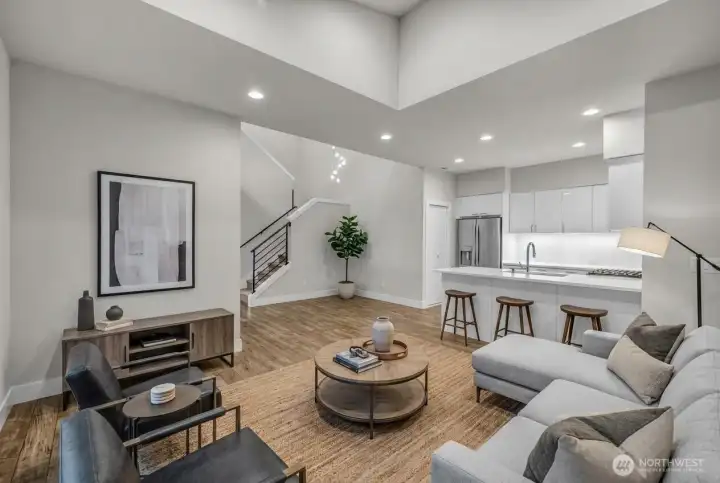 (Virtually Staged) Living room with high ceilings is open to kitchen.