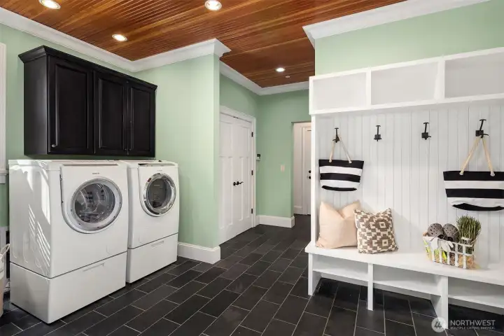 Side door entrance to a mud room with sink, storage and laundry.