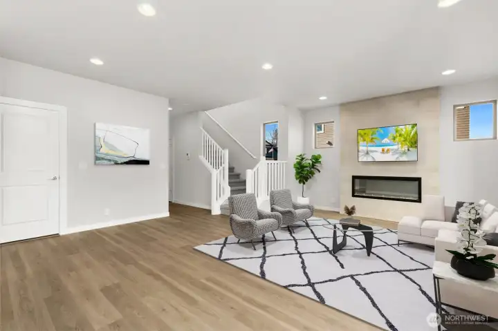 Spacious living area with the cozy full height electric fireplace. Virtually staged.