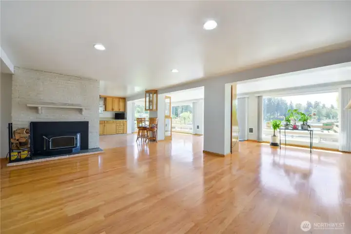 Spacious living room with cozy fireplace and the open concept kitchen in the background.