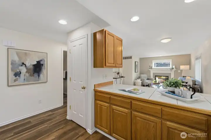 Kitchen with pantry and breakfast bar overlooking into the adjacent family room.