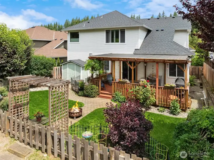 Garden beds, covered deck, outbuilding, grassy area and more!
