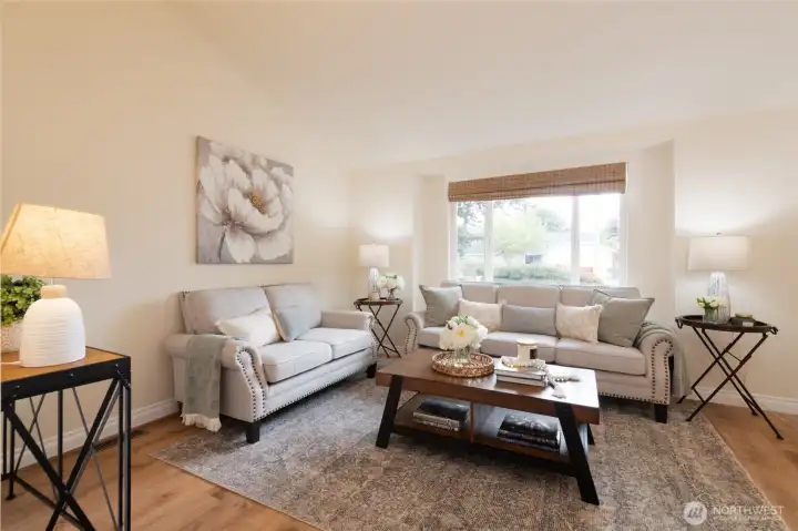 Vaulted ceilings elevate the spacious living room, creating a bright and airy atmosphere. Natural light pours in, making this an inviting space for relaxing or entertaining.