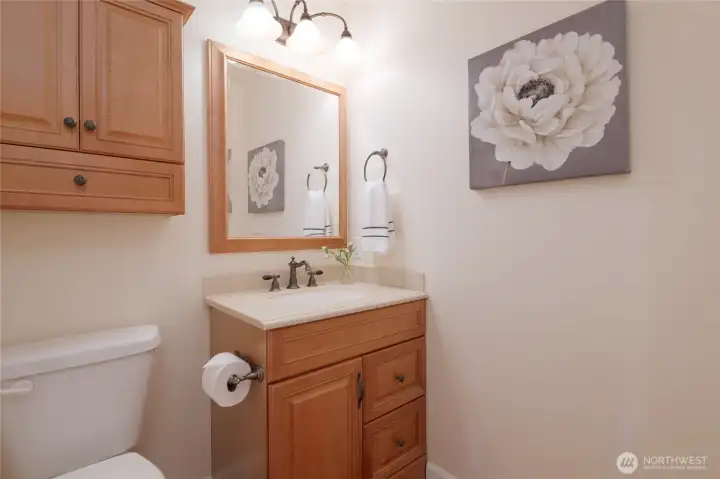 The main floor half bath is thoughtfully placed off of the main living area. It features plentiful storage and ready access from the main living areas.