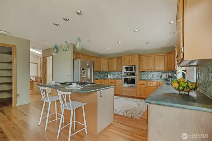 Stainless steel appliances, including double ovens, make entertaining a breeze, while designer pendant lights add a splash of artistic flair.