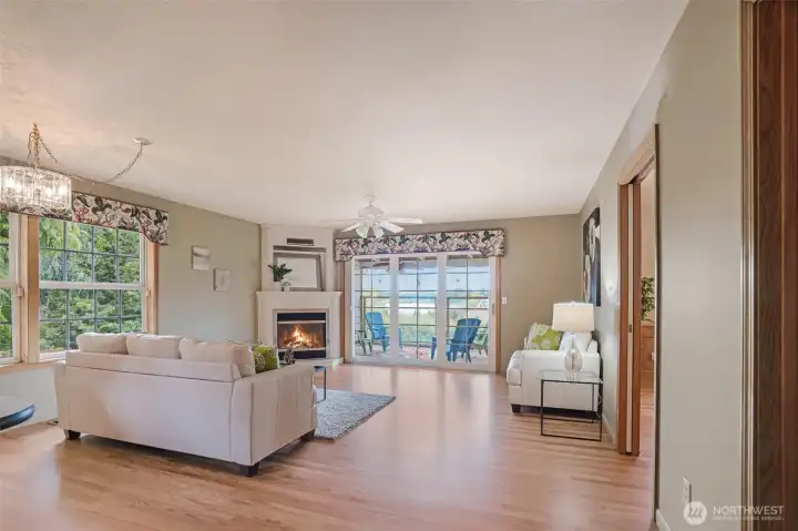 The spacious great room seamlessly connects to the gourmet kitchen and opens to a large covered deck, creating the perfect layout for indoor-outdoor living. Gather around the cozy gas fireplace, framed by custom millwork, or soak in peaceful lake views through a wall of windows and glass doors.