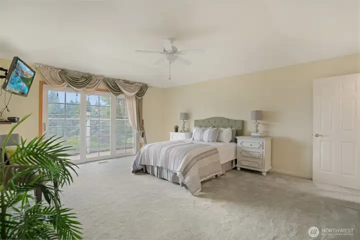 Welcome to the spacious and serene primary suite—your private retreat with peaceful lake views. Enjoy direct access to a secluded deck, perfect for morning coffee or evening unwinding. The generously sized bedroom features plush carpeting, soothing tones, and ample natural light. An en suite bath and an expansive walk-in closet complete the space, offering both comfort and convenience in a truly relaxing setting.