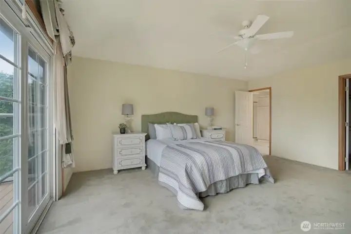 Another view of the Primary suite featuring serene lake views and direct access to a private deck.