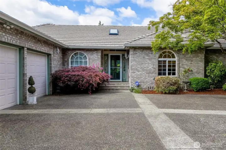 Inviting covered entry framed by mature Japanese maple.