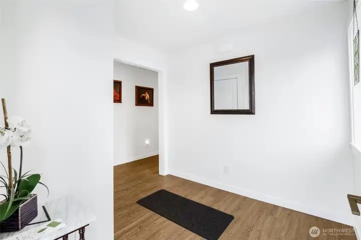 Around the corner from the third bedroom toward the front door.