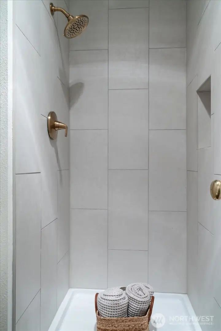 Italian-made 12" X 24" tile lines the walls of the primary suite's walk-in shower. (New frameless glass door to be installed mid-July.)